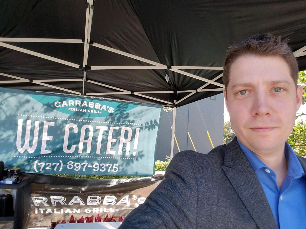 Carrabba’s Managing Partner taking a selfie in front a Carrabba’s sign at a blood drive event 