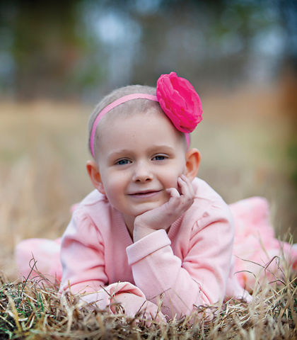cancer patient and blood recipient isabella posing on the grass