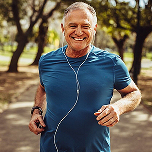 Man taking care of his health by jogging outside through a park