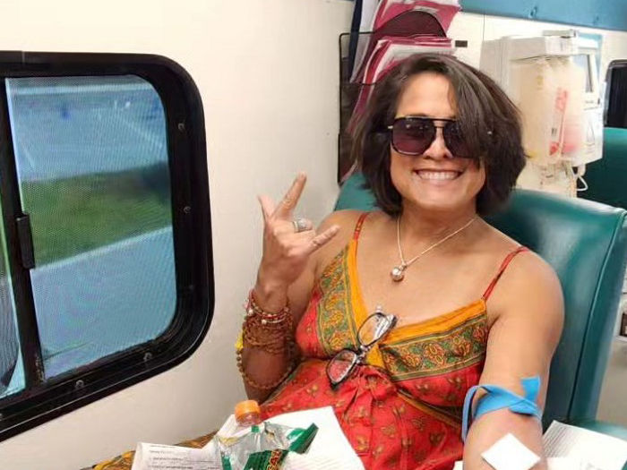 woman donating blood on the big red bus, happy