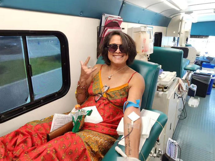 woman donating blood on the big red bus, happy