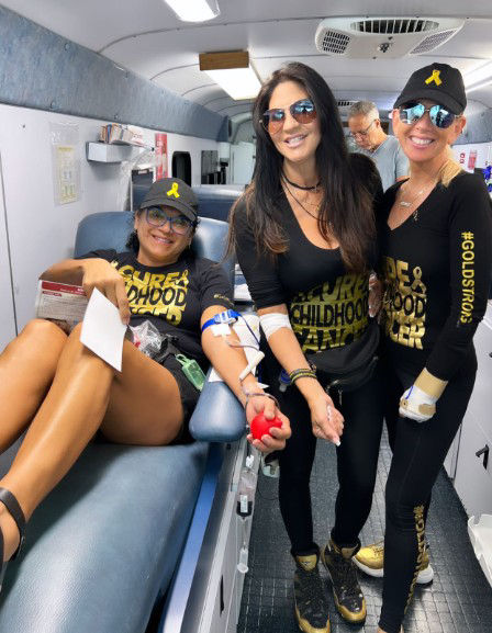 three women donating blood on the big red bus