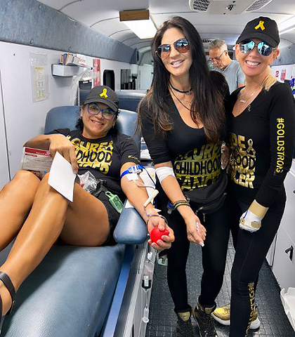 three women donating blood on the big red bus