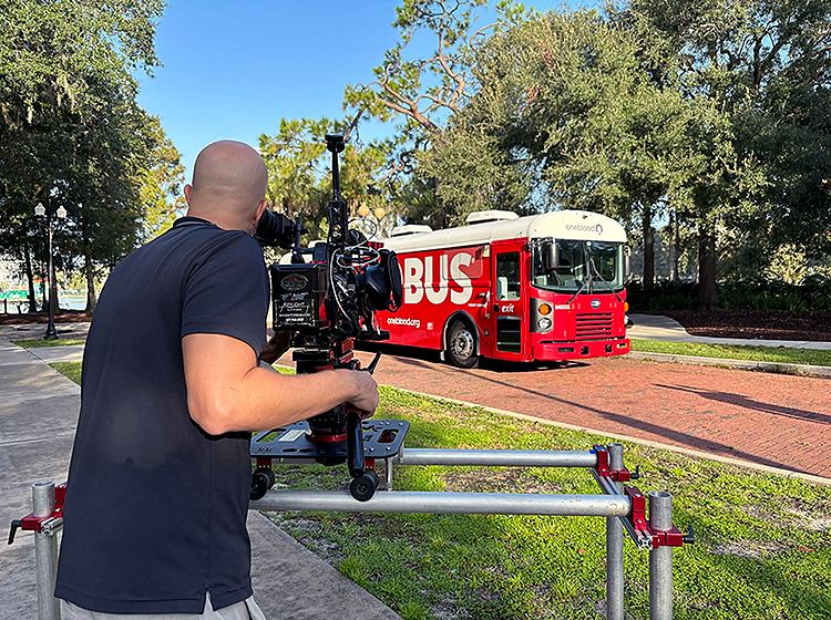 Camera man filming the Big Red Bus on a sunny day