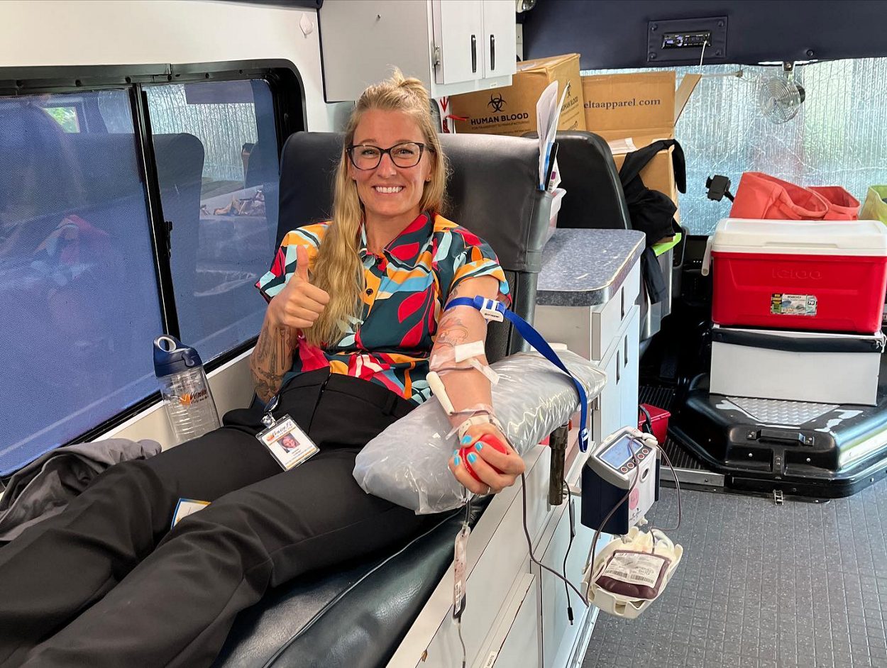 OneBlood donor with tattoos donating blood on a Big Red Bus