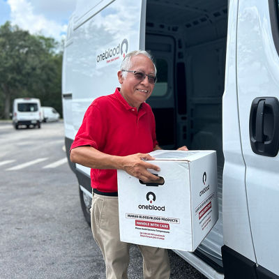 courier loading box with blood products to a van