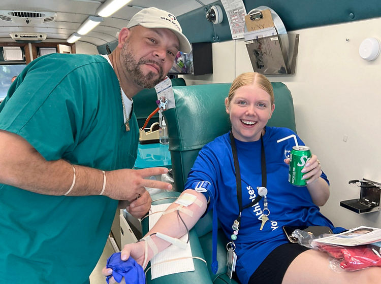 whole blood donor and phlebotomist on the big red bus