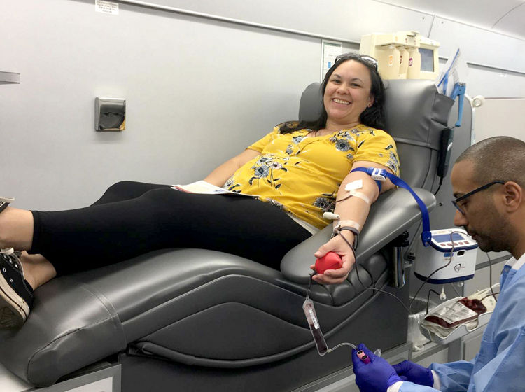 woman donating whole blood on the big red bus