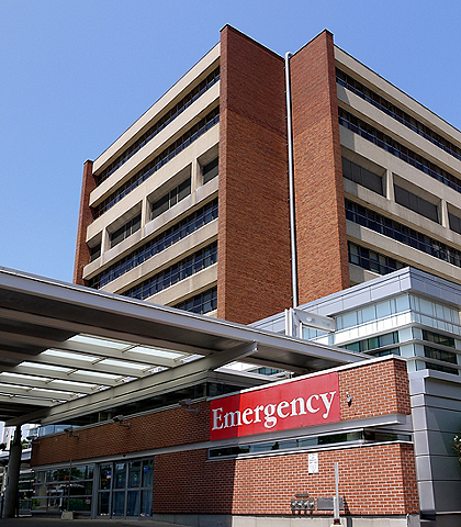 A modern hospital building, focussing on its emergency entrance.