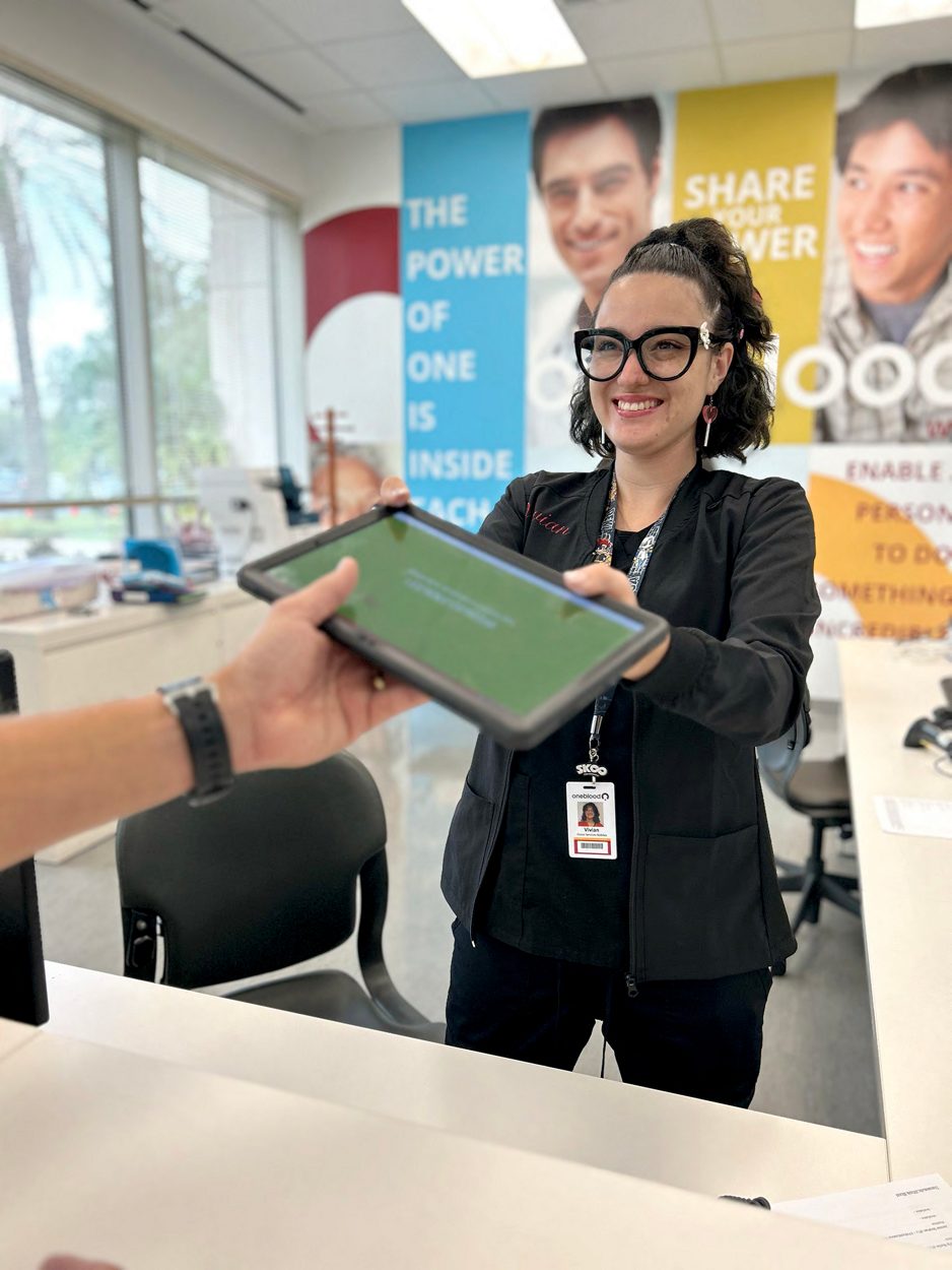 phlebotomist handing out an ipad to donor