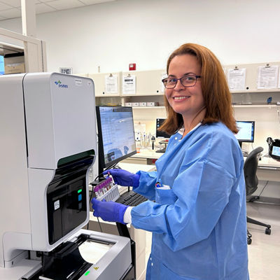 medical technologist woman standing, holding blood samples