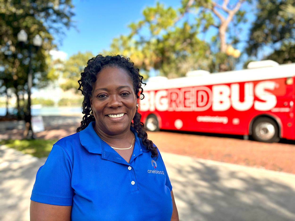 Phlebotomist standing outside of the Big Red Bus