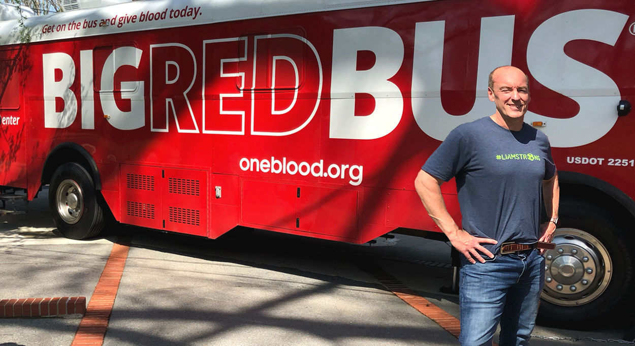 Shawn standing in front of the Big Red Bus